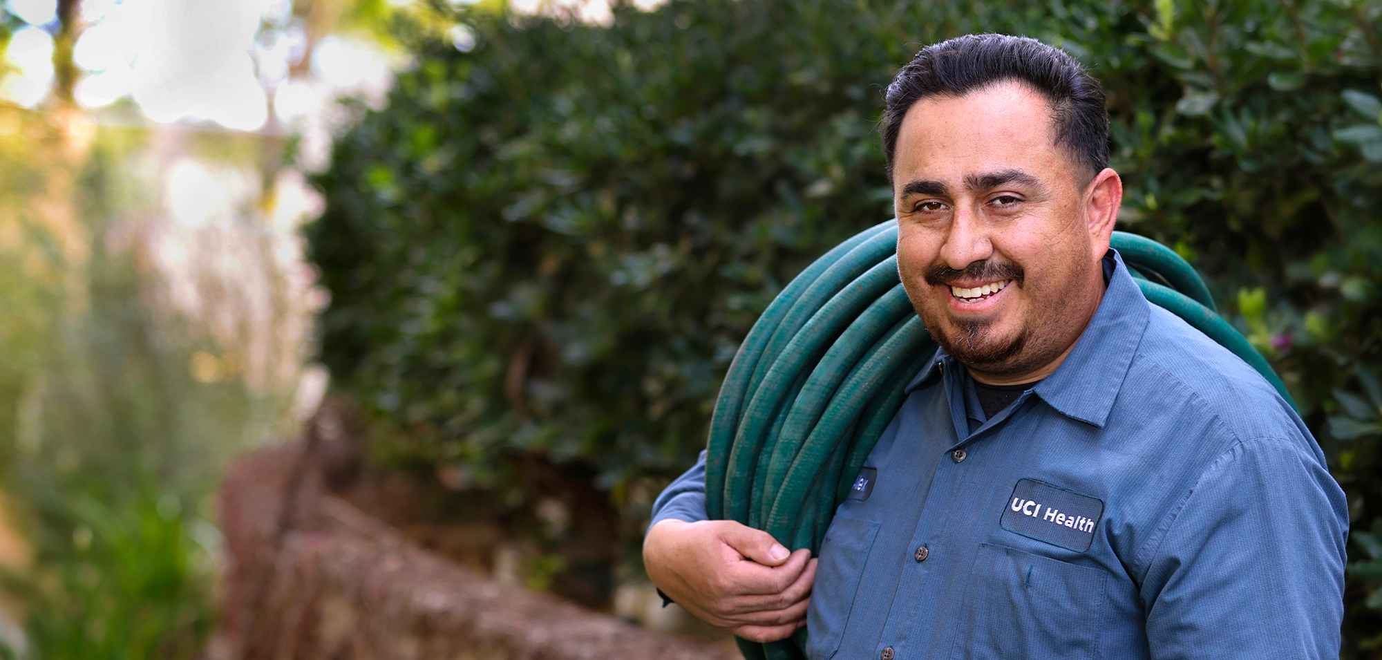 facilities staff member holding a water hose