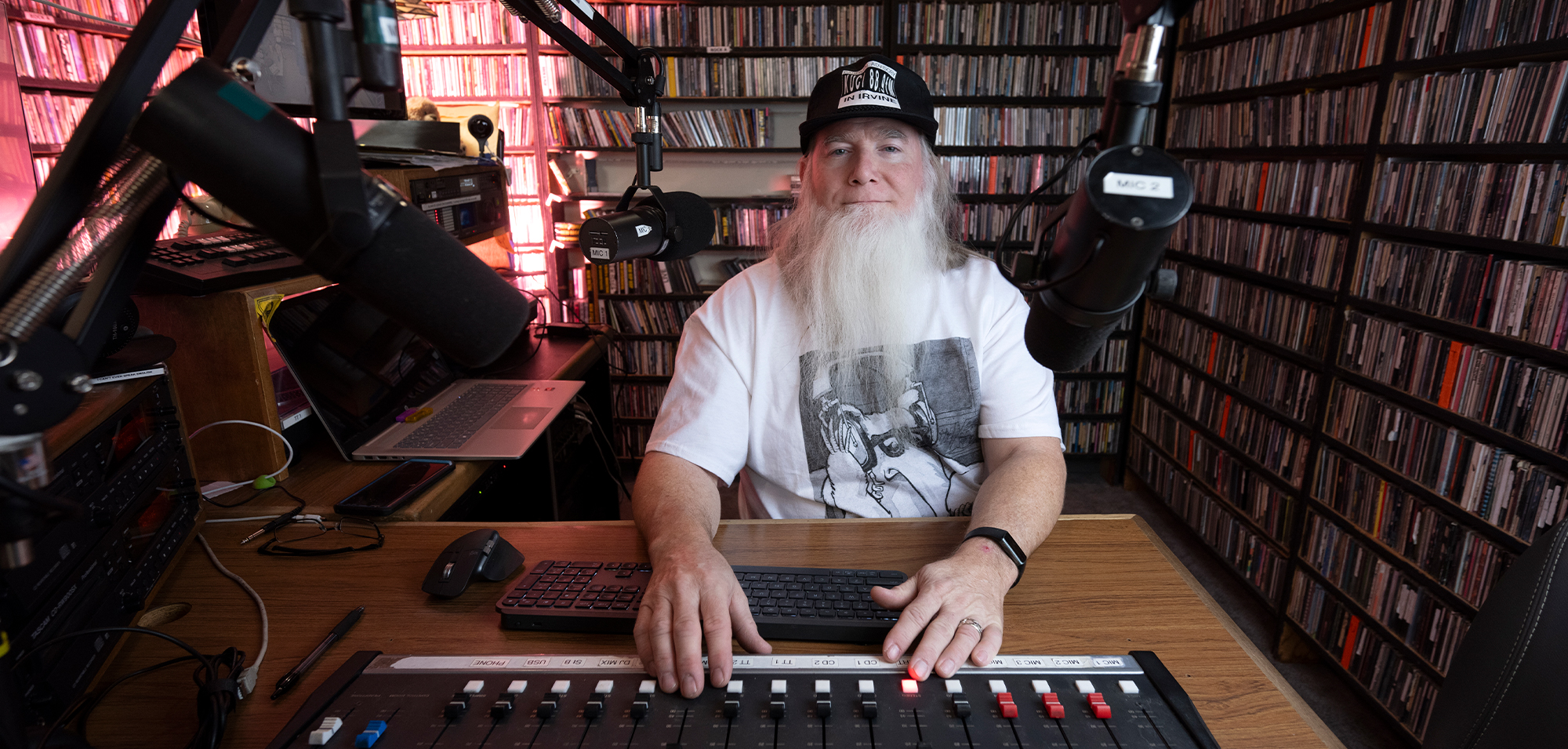 radio station producer sitting in front of sound board